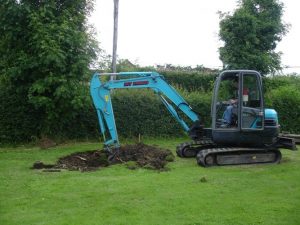 Man with a digger digging a whole